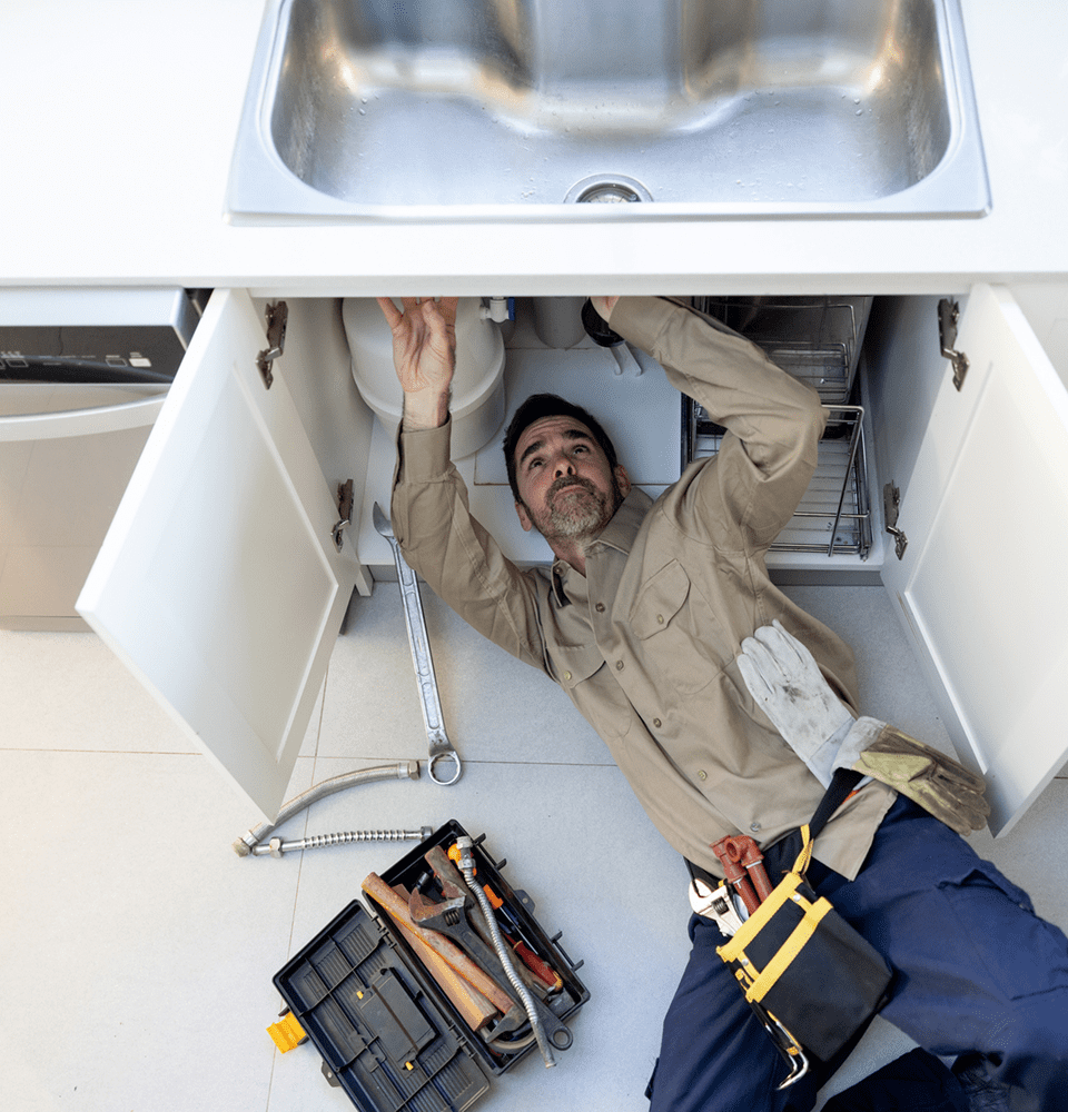 Technician working on kitchen sink maintenance